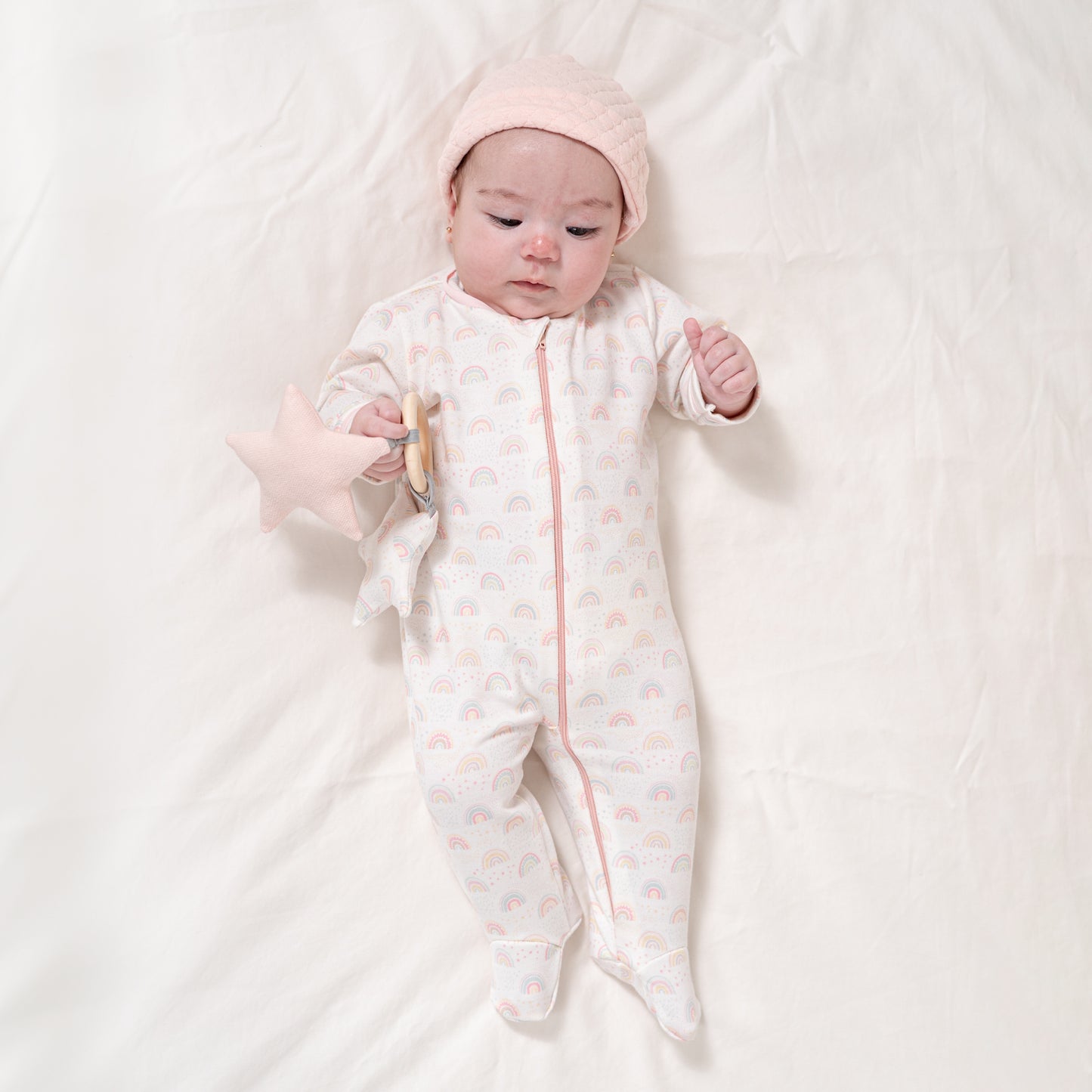 Cesto recién nacido mameluco arcoíris rosa.